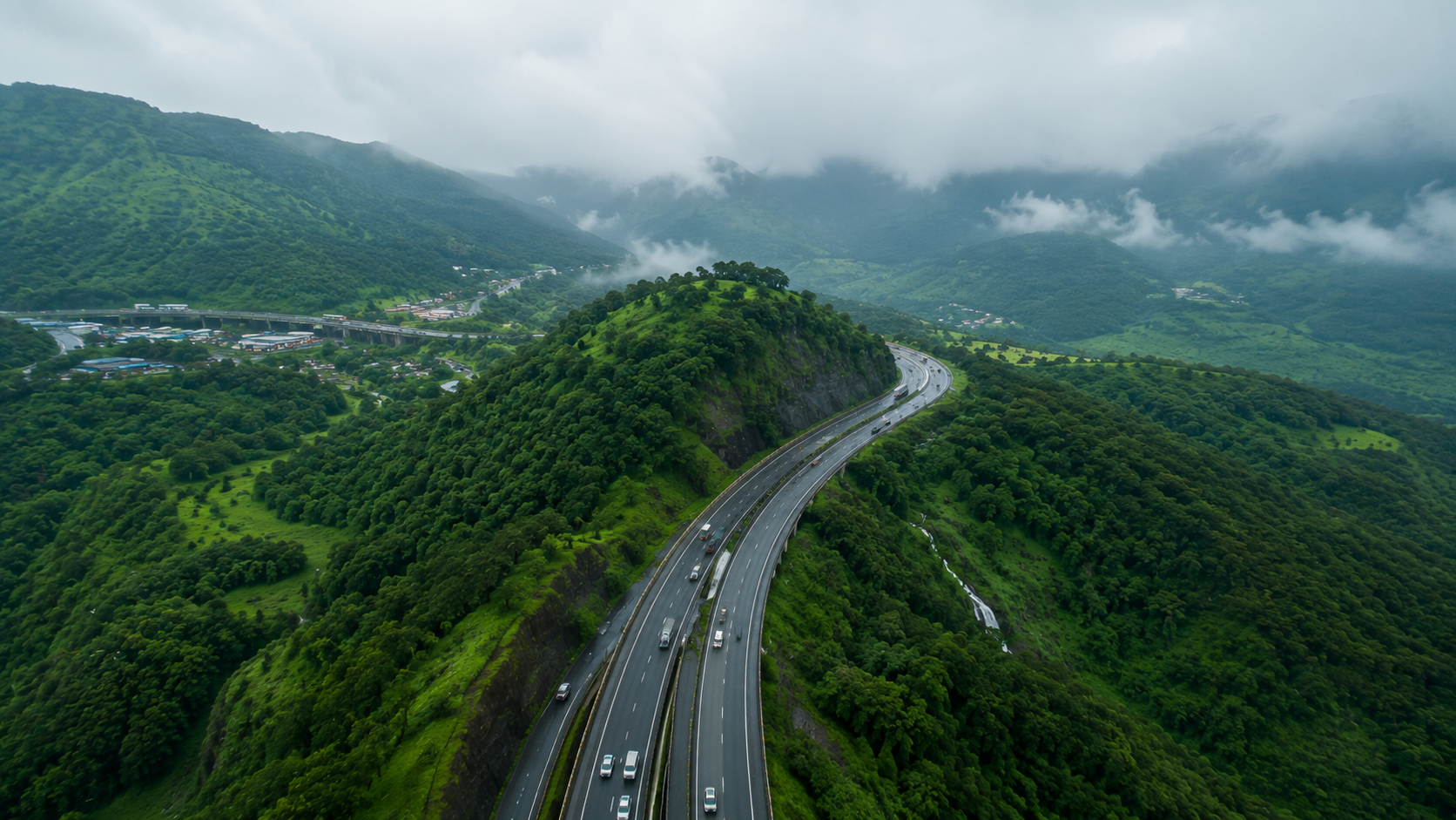 Aerial drone view of the Mumbai-Pune Expressway winding through green Sahyadri hills