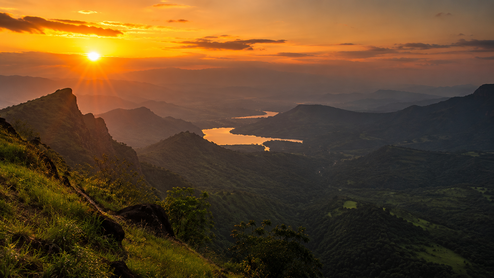 Orange sunset sky over the green Sahyadri valley seen from Duke's Nose near Khandala