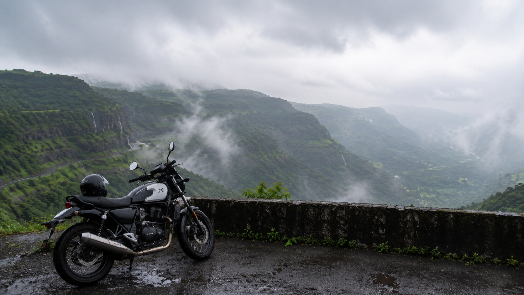 Motorbike parked at a misty ghat-road viewpoint overlooking the Sahyadri valley on the Mumbai to Lonavala route