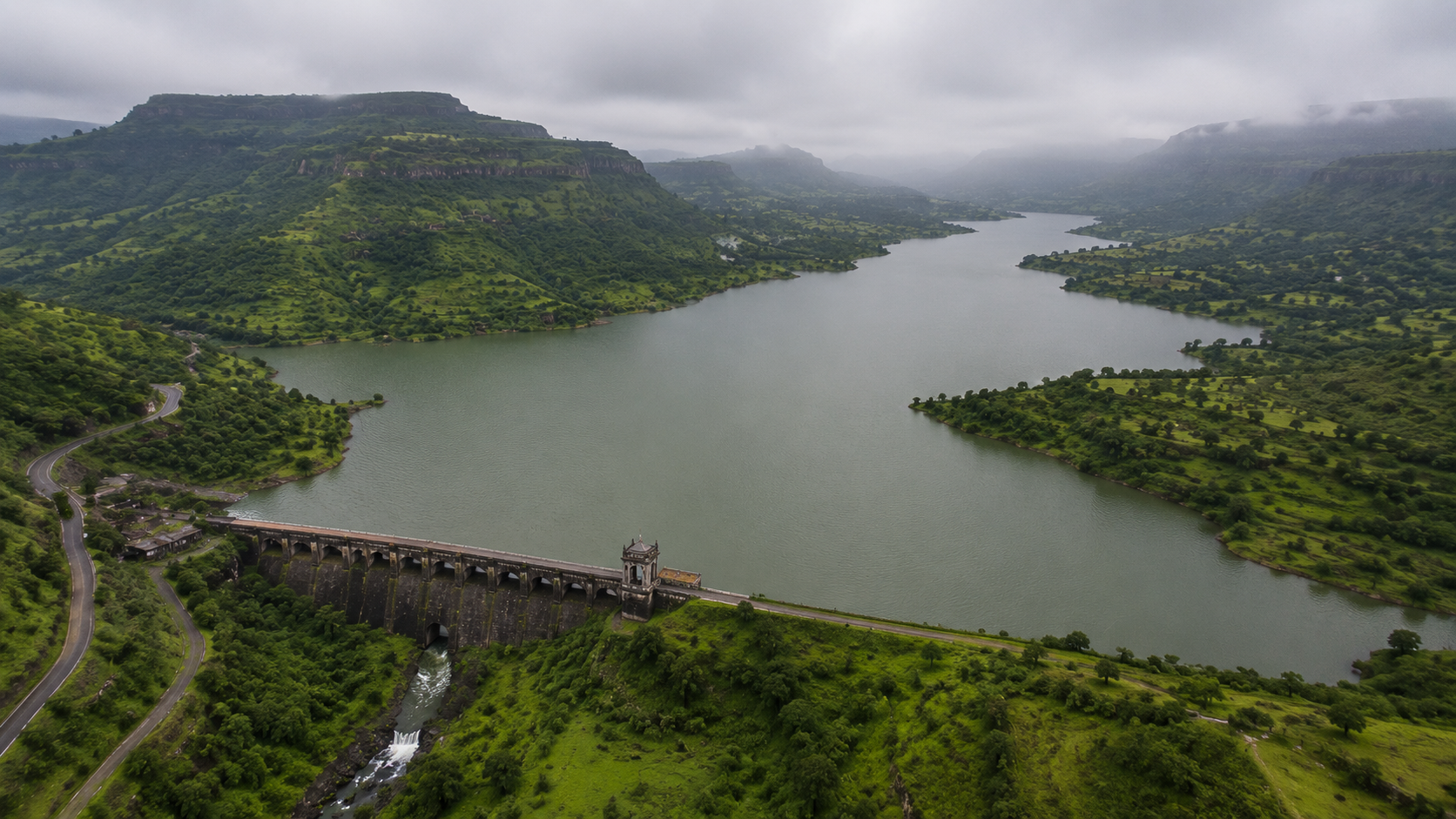 Aerial drone view of the green Arthur Lake and Wilson Dam surrounded by hills near Bhandardara